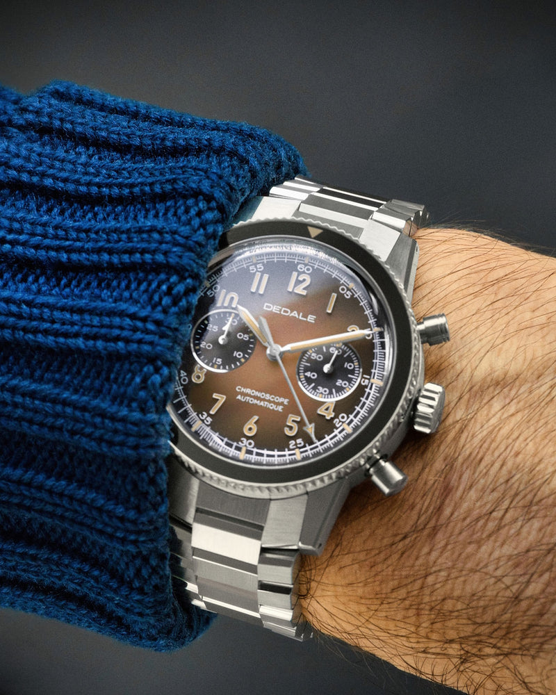 Montre de pilote DÉDALE Waypoint WP-01 ALFA ZULU avec son cadran marron dégradé et son bracelet en acier inoxydable WingSteel porté.