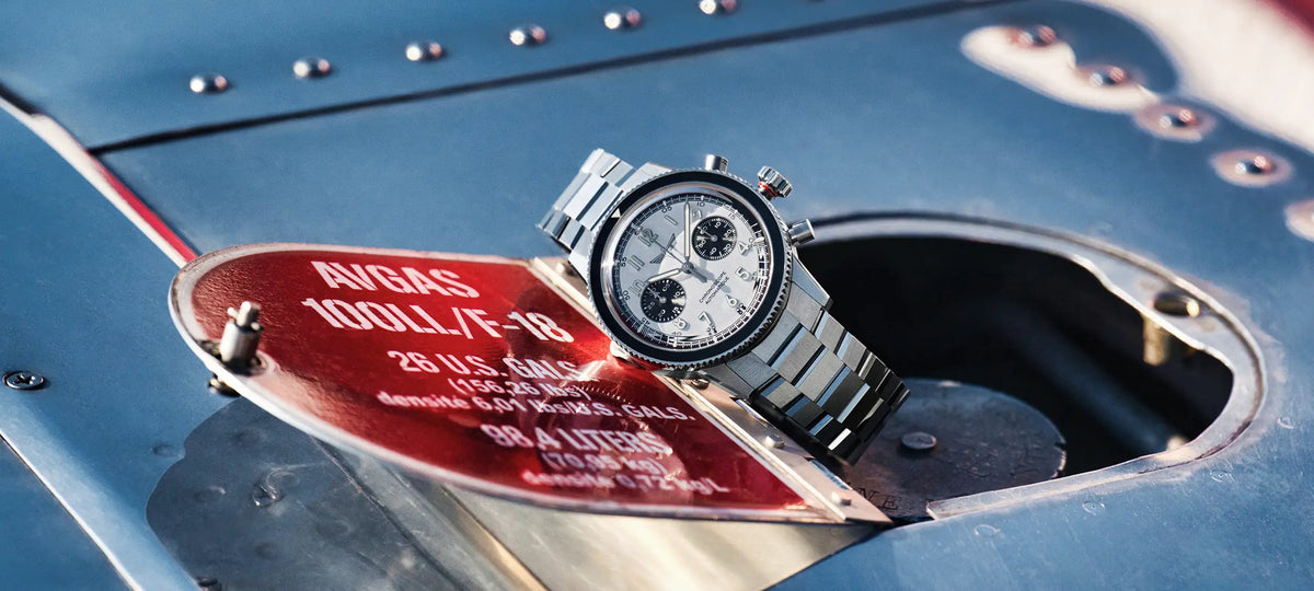 Chronographe pilote Dédale sur une aile d'avion Globe Swift en aluminium poli, trappe essence ouverte, autocollant indications essence en rouge