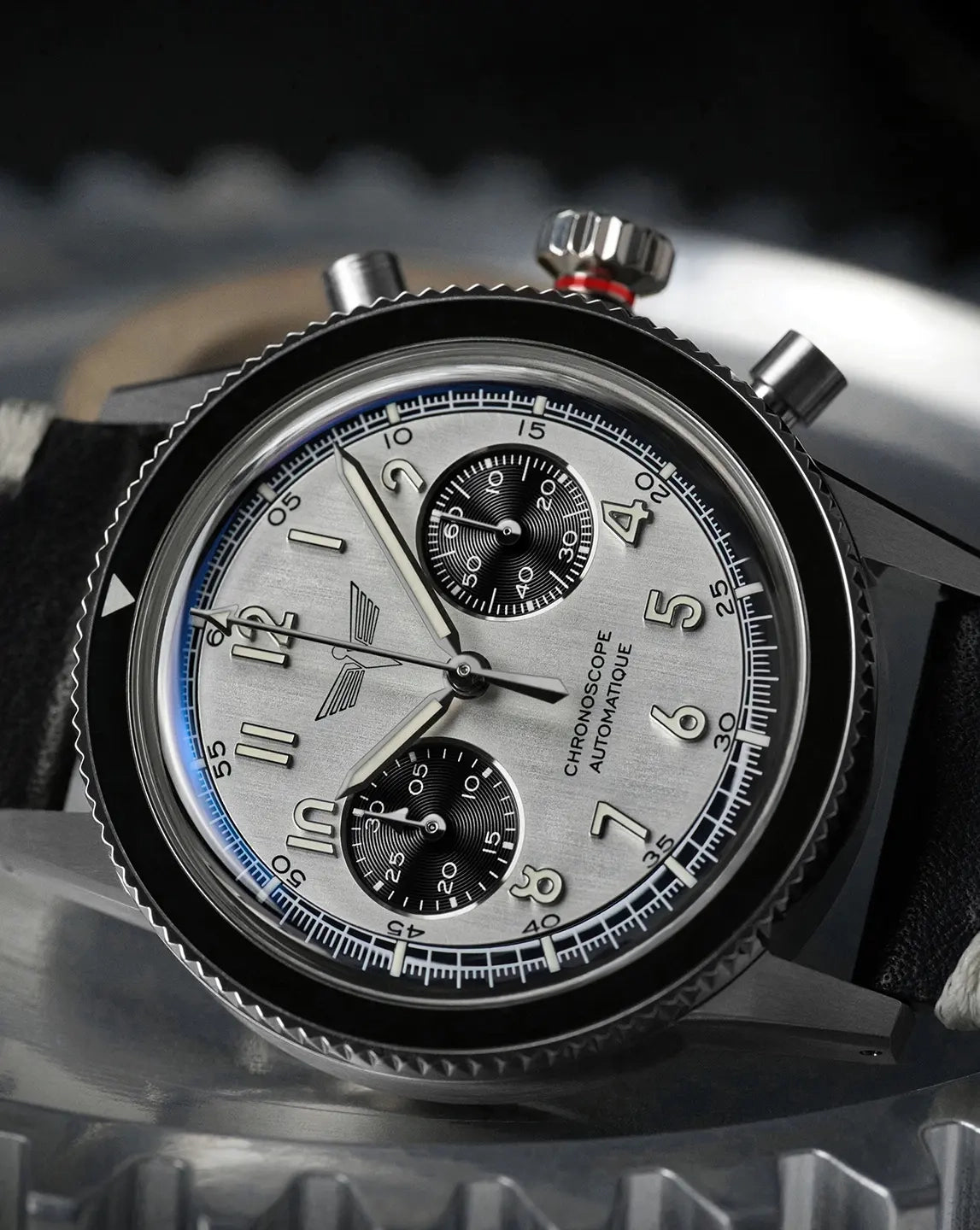 Couronne vissée avec témoin rouge de la montre DÉDALE, index appliqués et poussoir forme de piston d'avion